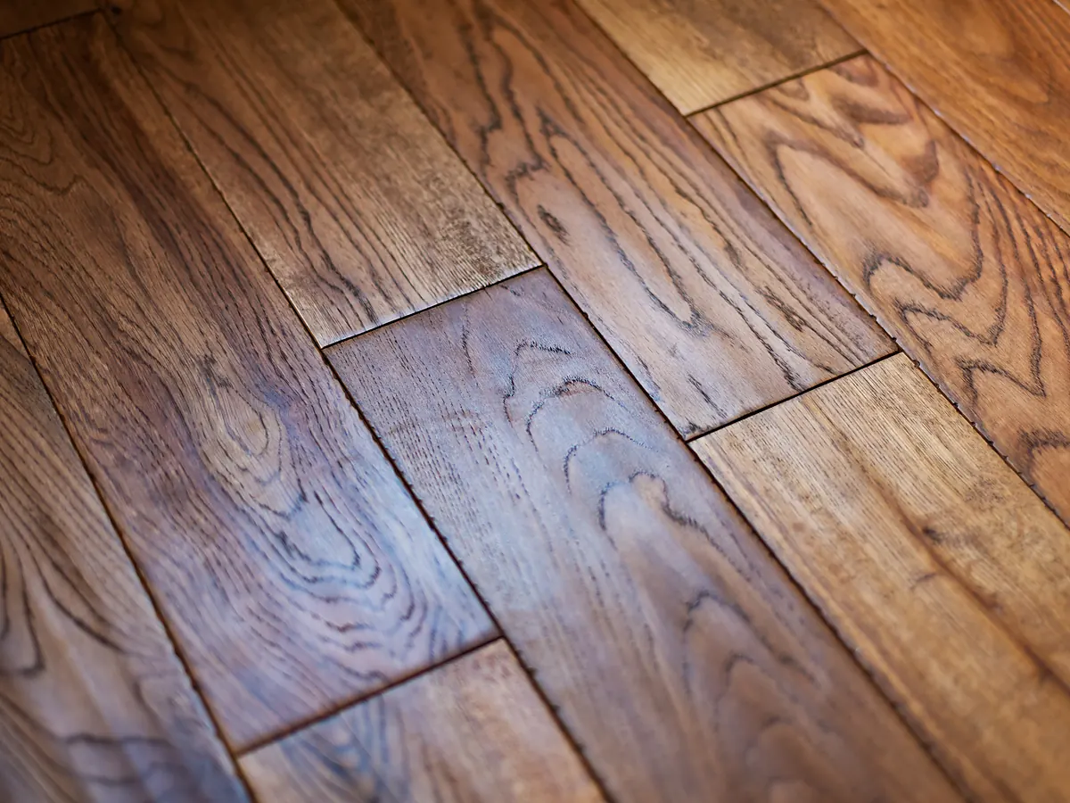 Close-up of a finished hardwood floor showing topcoat sheen across the grain