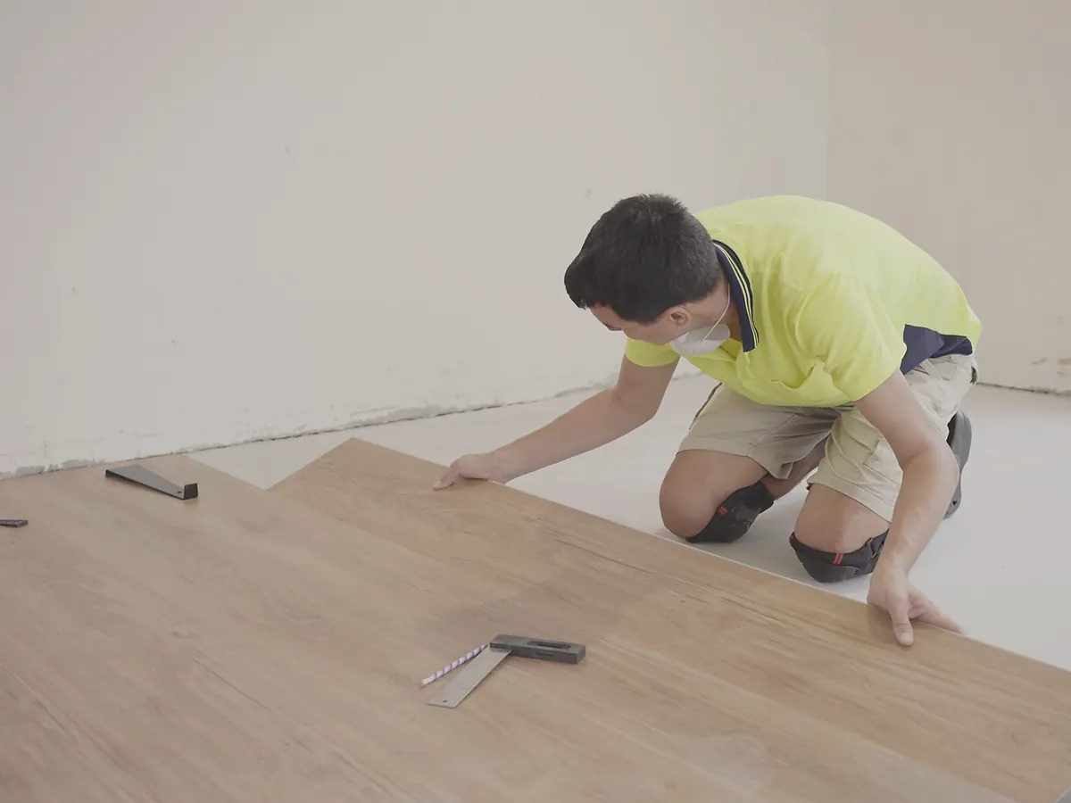 Installer fitting AC4-rated laminate flooring planks in a Sioux Falls, SD home