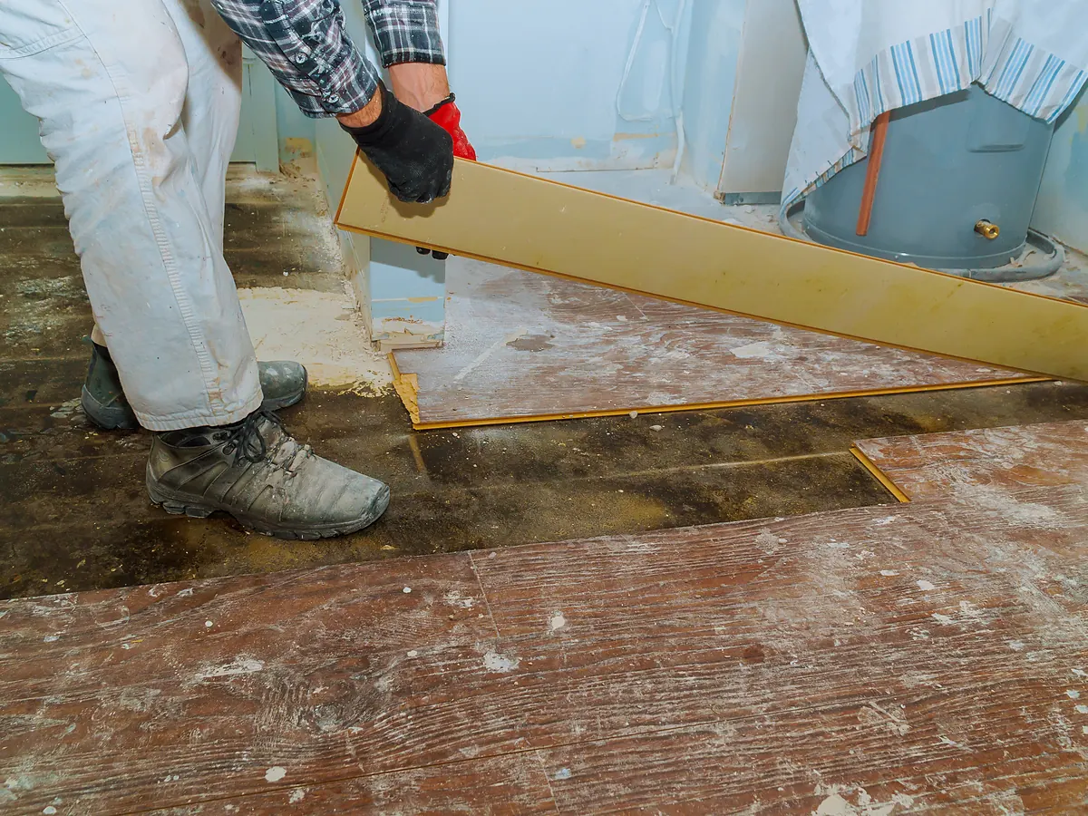 Water-damaged hardwood boards lifted to dry the structure before repair in Sioux Falls, SD